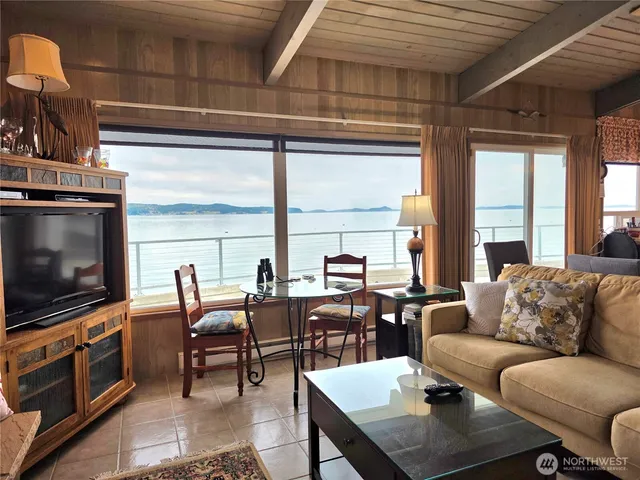 a living room with furniture a flat screen tv and a floor to ceiling window
