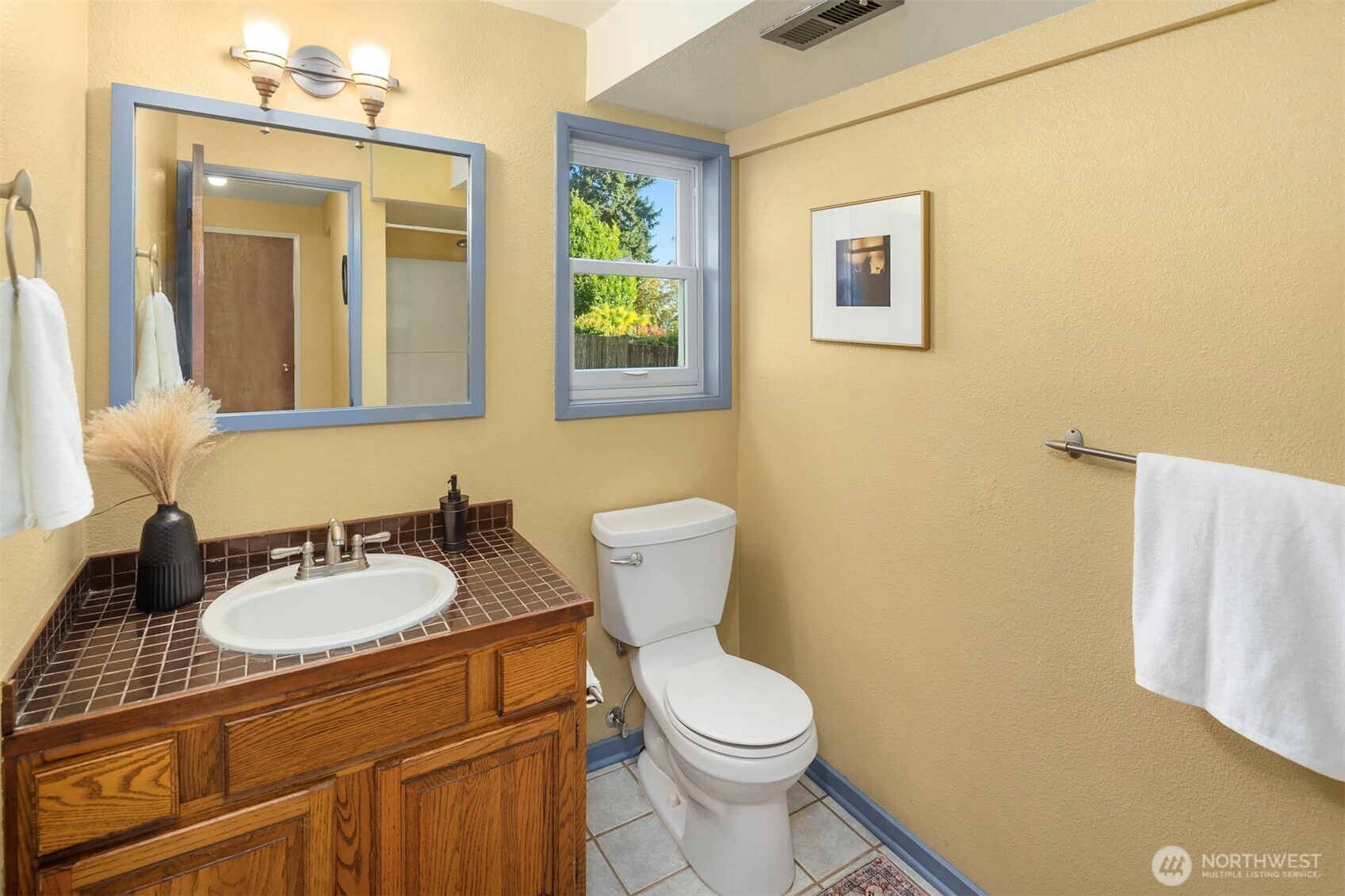 10514 Southwest 110th Street Vashon, WA 98070 - Photo 25 of 38 a bathroom with a granite countertop toilet sink and mirror