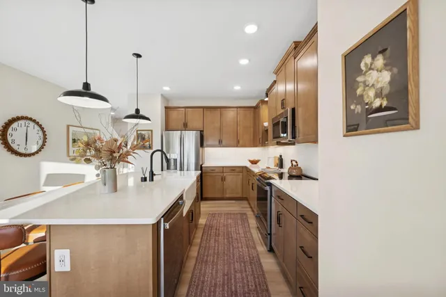 a kitchen with stainless steel appliances granite countertop a sink a stove and a wooden floors