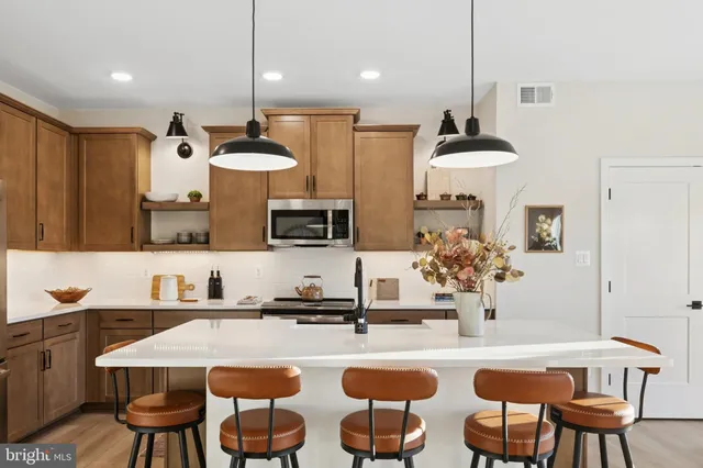 a kitchen with stainless steel appliances granite countertop a sink a stove and a refrigerator