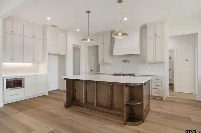 a kitchen with kitchen island a stove a sink and a refrigerator