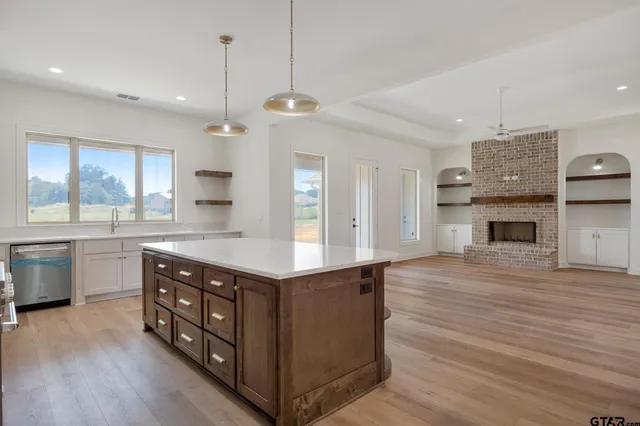 a kitchen with stainless steel appliances granite countertop a sink a stove and a wooden floors