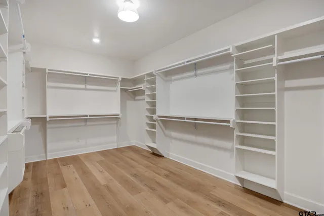 a room with walk in closet and empty racks