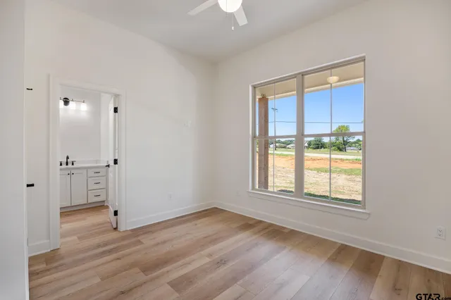 an empty room with wooden floor and a window
