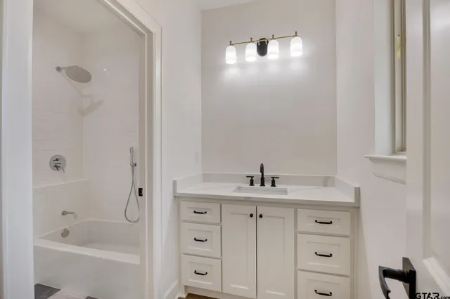 a bathroom with a granite countertop sink a toilet and shower