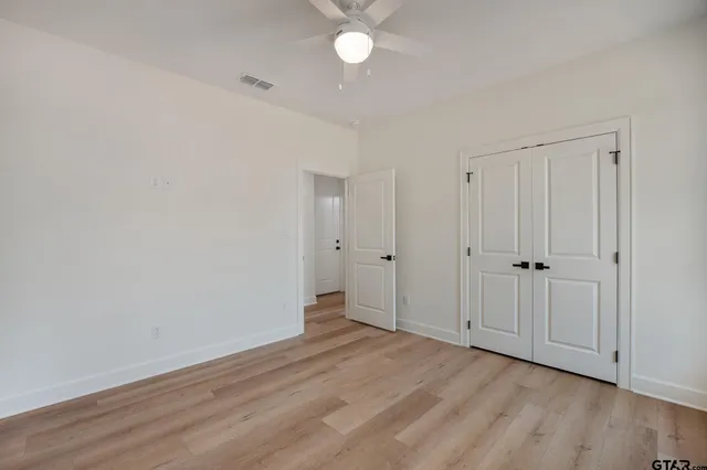 a view of an empty room with wooden floor