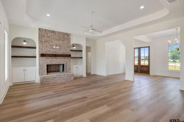 a view of empty room with wooden floor and fireplace