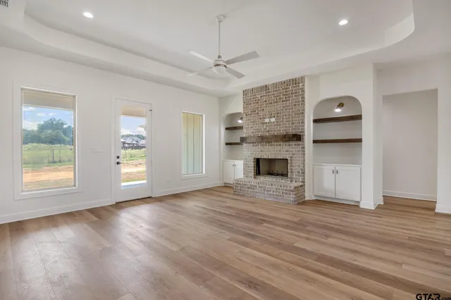an empty room with windows and a fireplace
