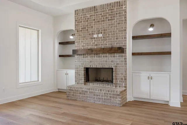 a living room with a fireplace and a wooden floor