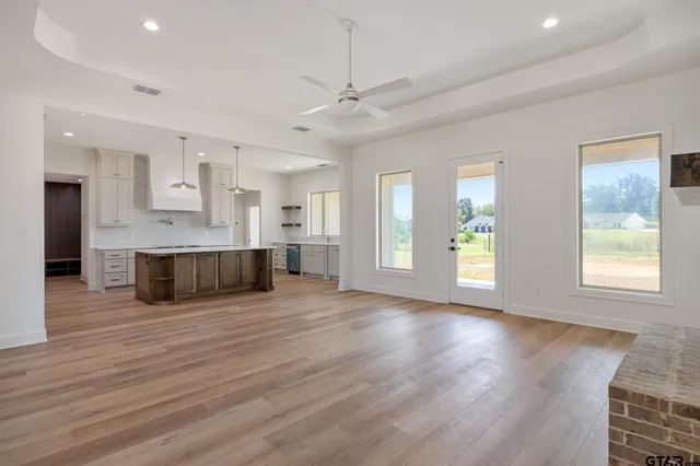 a view of a big room with wooden floor and windows