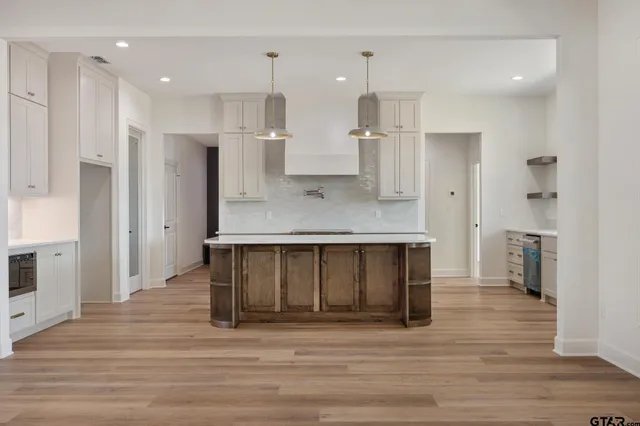 a kitchen view with stainless steel appliances kitchen island granite countertop a refrigerator and a sink