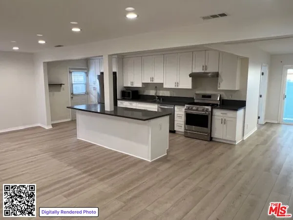 a kitchen with stainless steel appliances granite countertop a stove top oven a sink and a refrigerator