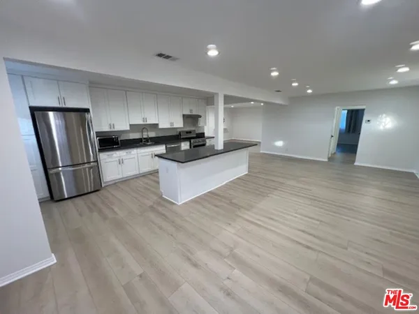 a kitchen with stainless steel appliances a refrigerator sink and microwave