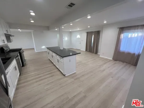 a large hall with kitchen island granite countertop a large window in it