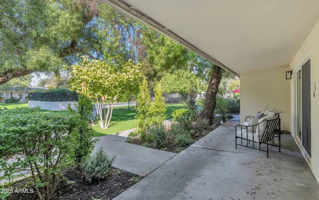 a view of a chair and table in the backyard