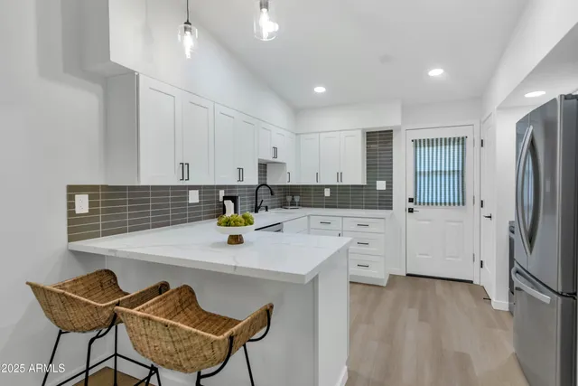 a kitchen with a refrigerator a stove a sink dishwasher and white cabinets with wooden floor