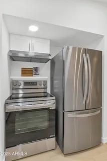 a view of a kitchen with refrigerator and cabinets