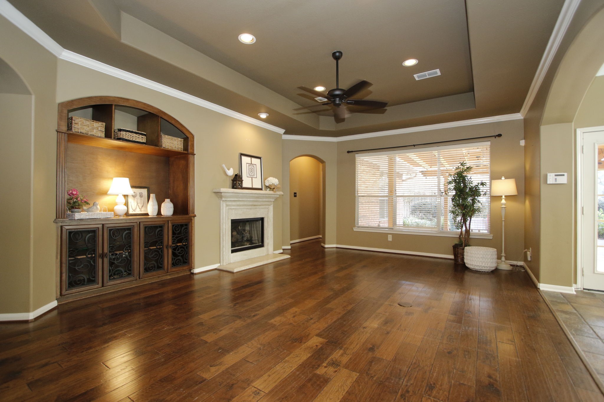 9203 Memorial Pines Way Spring, TX 77379 - Photo 13 of 45 This spacious family room features warm wood flooring, a cozy fireplace, built-in shelving, and large windows that provide ample natural light.