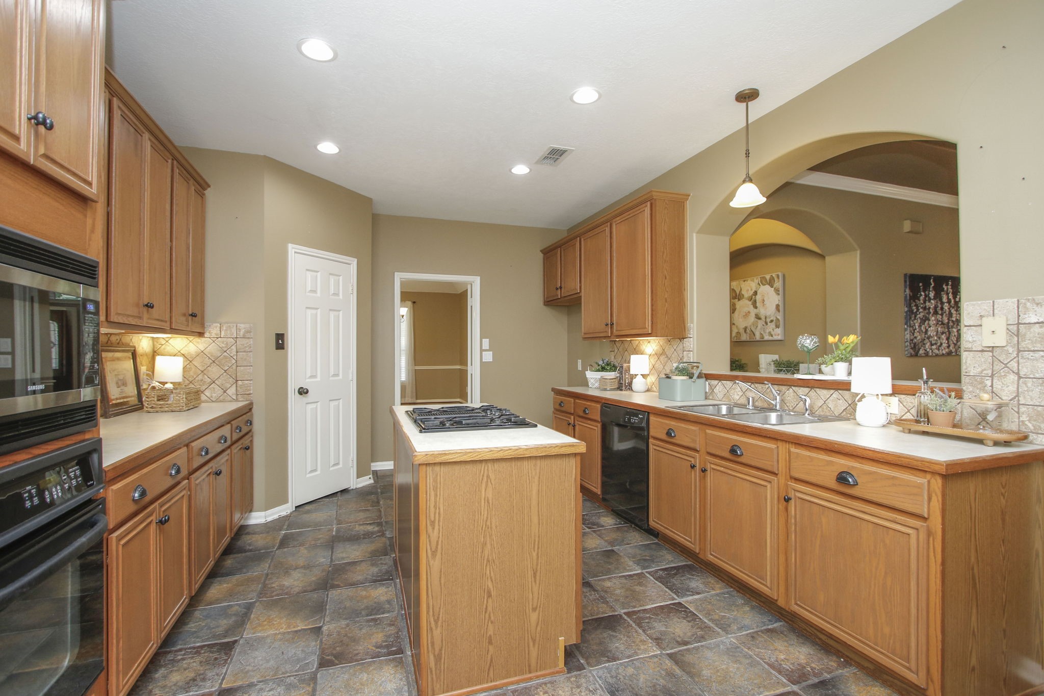 9203 Memorial Pines Way Spring, TX 77379 - Photo 18 of 45 The kitchen has tiled flooring, recessed lighting, electric oven and microwave plus gas stovetop.