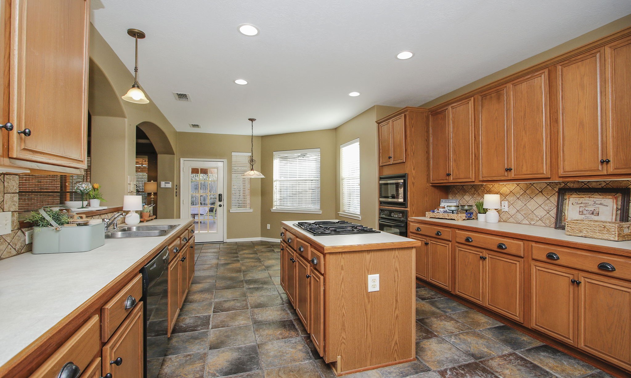 9203 Memorial Pines Way Spring, TX 77379 - Photo 19 of 45 Natural light fills the kitchen through large windows, and recessed lighting adds a modern touch.