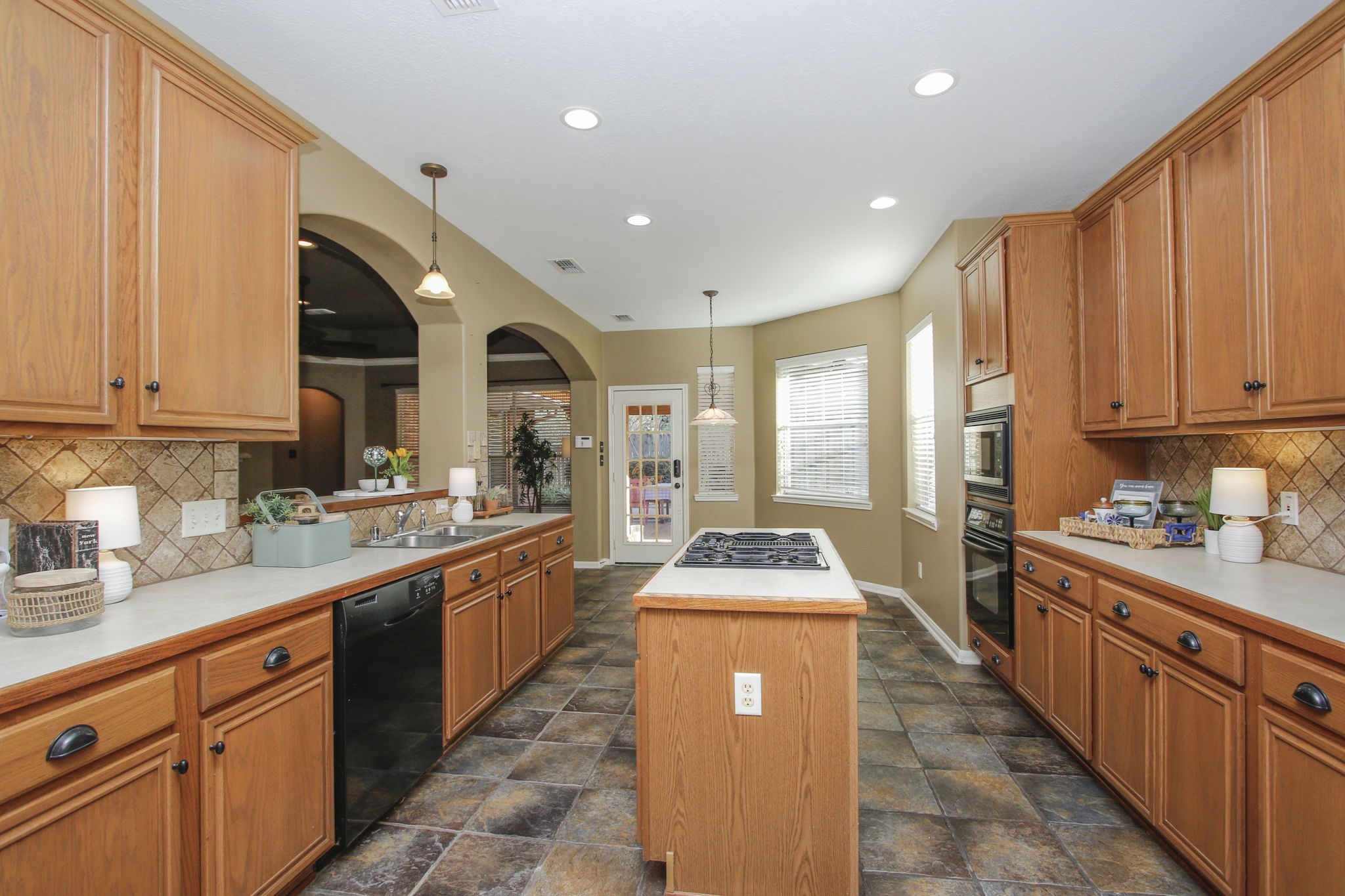 9203 Memorial Pines Way Spring, TX 77379 - Photo 20 of 45 This spacious kitchen has stylish tile flooring, recessed lighting, and a cozy breakfast nook with large windows for natural light.