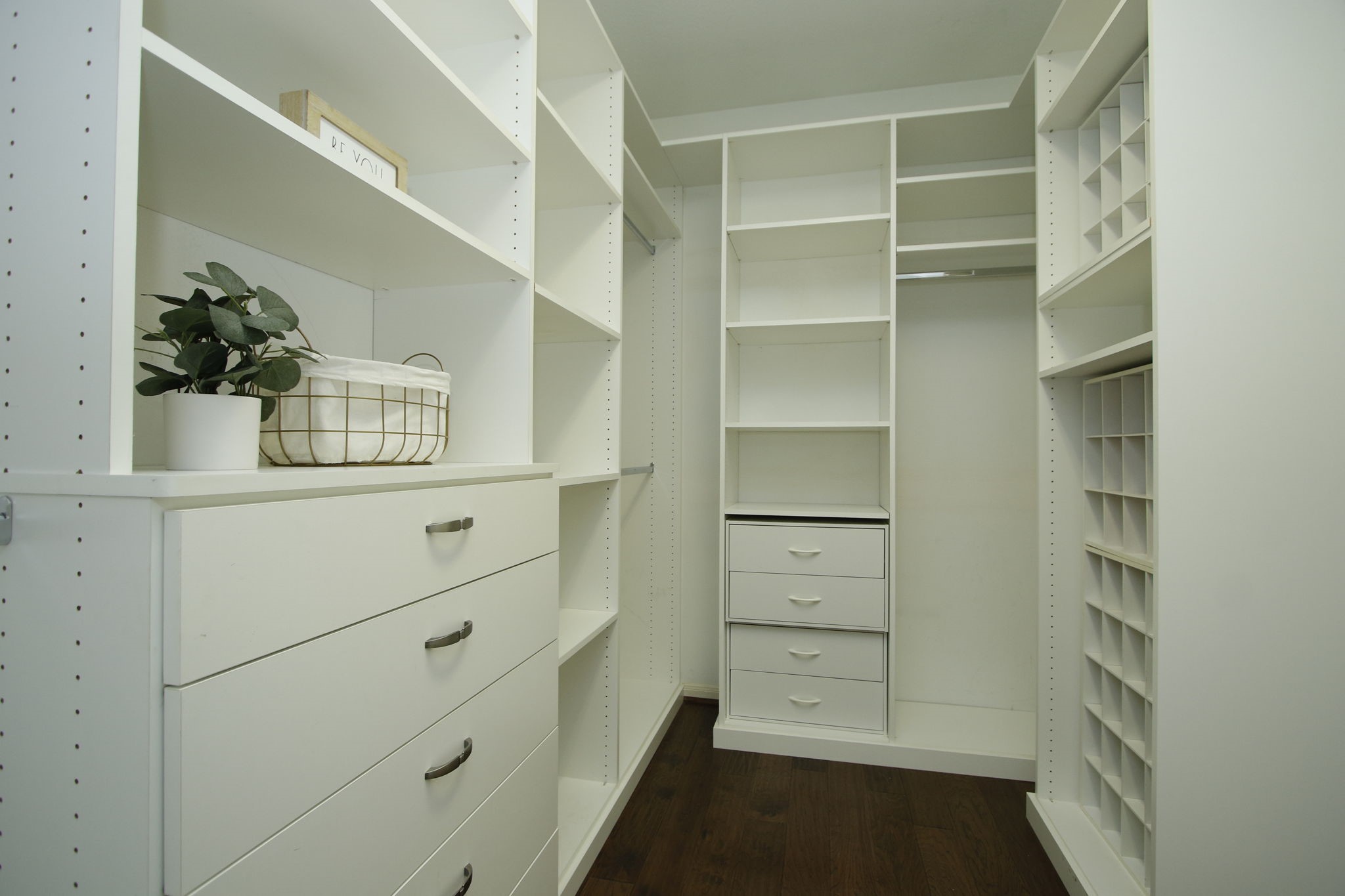 9203 Memorial Pines Way Spring, TX 77379 - Photo 23 of 45 The primary bedroom has a spacious walk-in closet with ample shelving, drawers, and hanging space, featuring white cabinetry and dark hardwood floors.