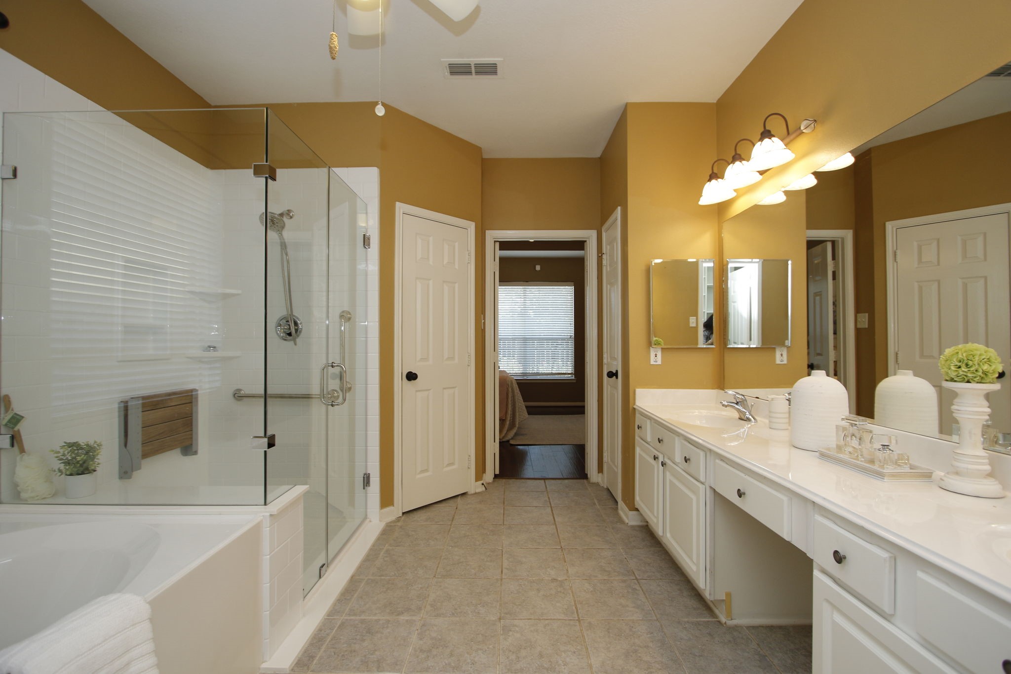 9203 Memorial Pines Way Spring, TX 77379 - Photo 25 of 45 The primary bathroom features a spacious layout with a large glass-enclosed shower, a separate bathtub, dual sinks with a wide vanity, and ample lighting.