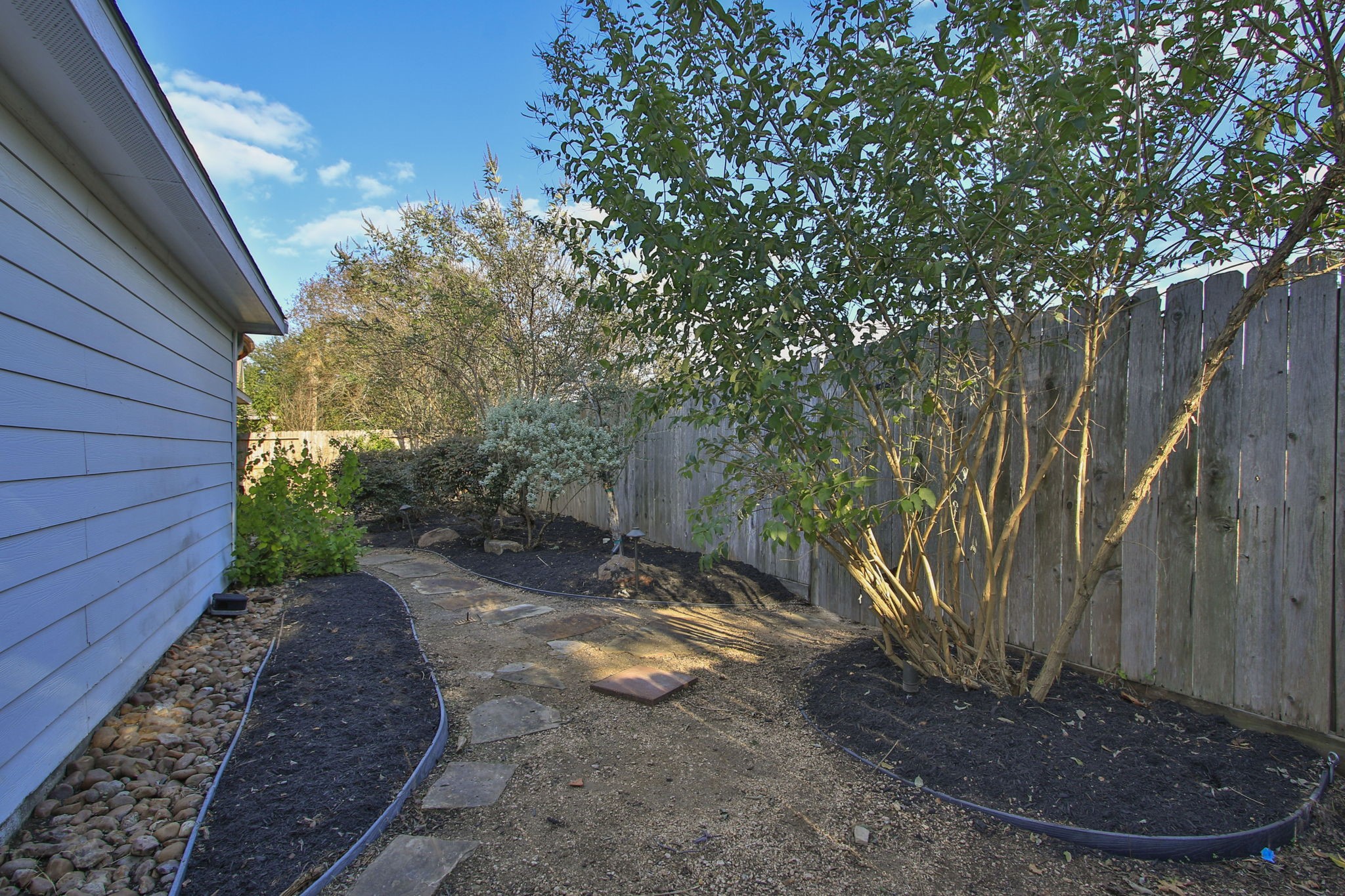 9203 Memorial Pines Way Spring, TX 77379 - Photo 42 of 45 This is another view of the backyard featuring a narrow garden path lined with stepping stones.