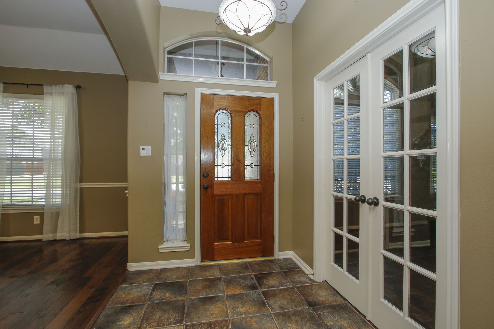 9203 Memorial Pines Way Spring, TX 77379 - Photo 9 of 45 A welcoming entryway features a lead glass front door with an arched transom window. Adjacent are elegant French doors leading to a home office or 4th bedroom.