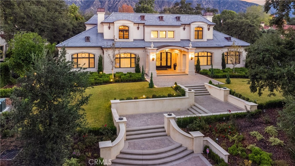 a front view of a house with a yard and lake view