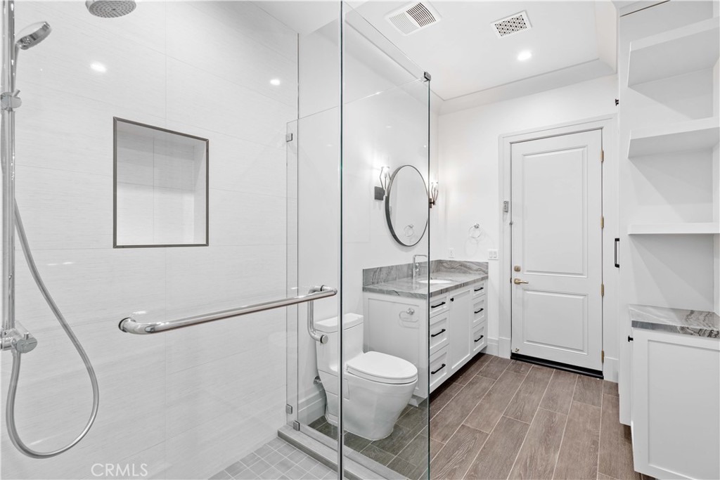 911 Hampton Road Arcadia, CA 91006 - Photo 55 of 73 a bathroom with a granite countertop sink a toilet a mirror and a shower