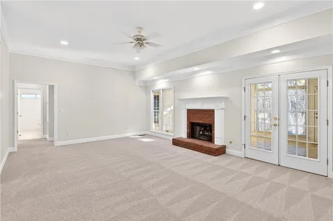 a view of an empty room with a window and a fireplace