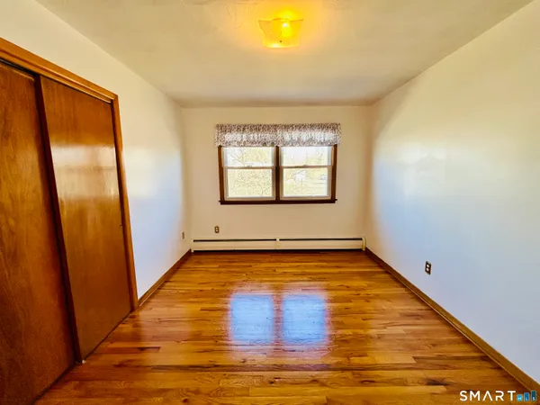 a view of a room with wooden floor and window
