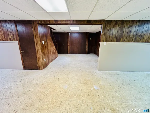 a view of an empty room with wooden floor and stairs