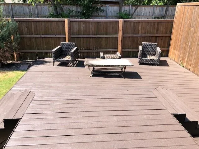 a white bench sitting next to a small yard