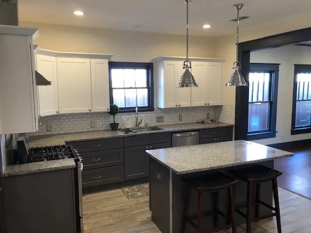 a kitchen with granite countertop a sink stove and refrigerator