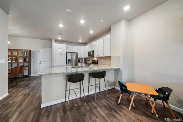 a kitchen with cabinets and wooden floor