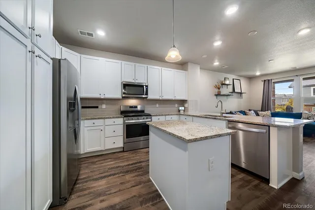 a kitchen with stainless steel appliances granite countertop a refrigerator sink and cabinets