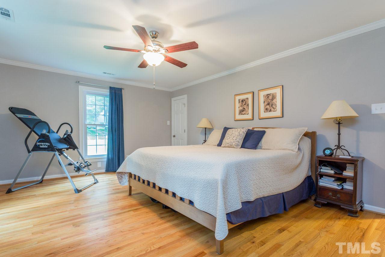 412 Amelia Avenue Raleigh, NC 27615 - Photo 15 of 25 a bedroom with a bed and a chandelier