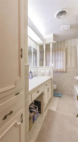 a bathroom with a double vanity sink toilet and a mirror