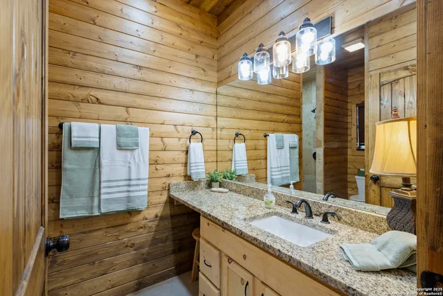 a bathroom with a granite countertop sink and a mirror