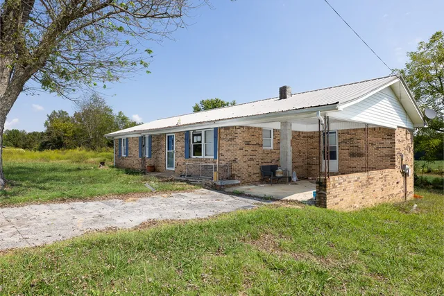 a view of a house with backyard and sitting area