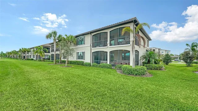 a front view of multi story residential apartment building with yard and outdoor seating