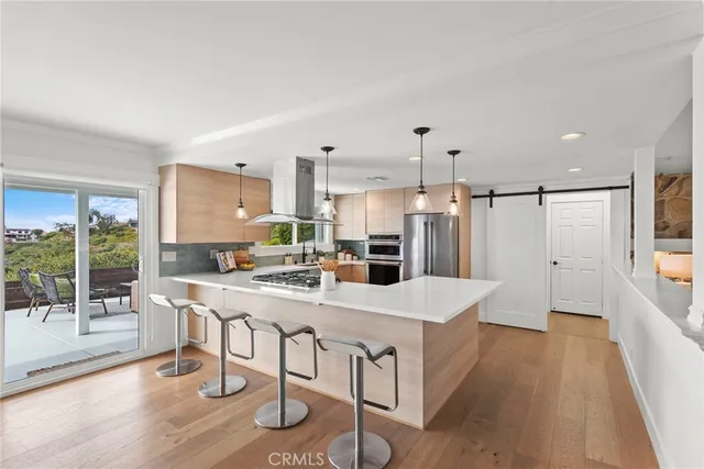 a kitchen with kitchen island granite countertop a sink a counter space and stainless steel appliances