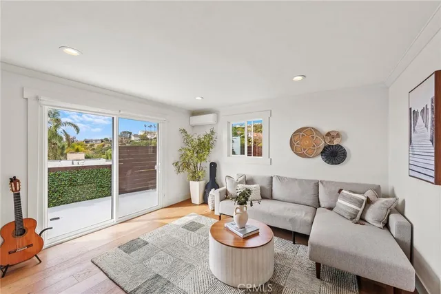 a living room with furniture a flat screen tv and a floor to ceiling window