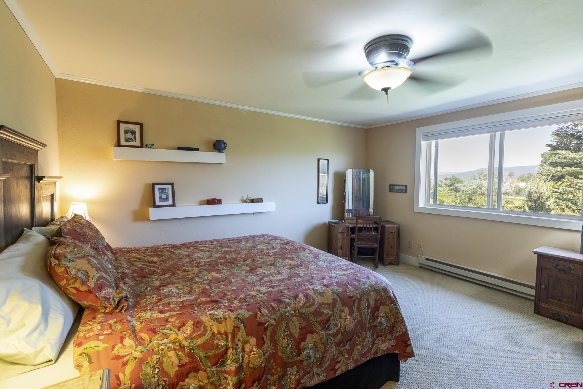 11450 Crawford Road Paonia, CO 81428 - Photo 17 of 41 a bedroom with a large bed and a chandelier