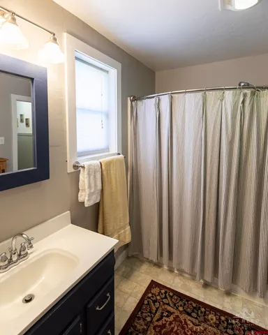 a bathroom with a sink a mirror and a shower curtain