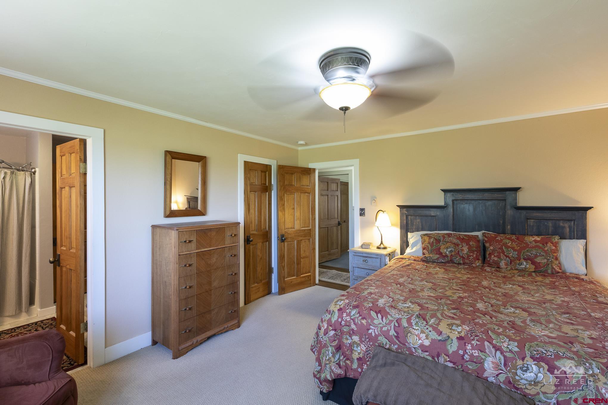 11450 Crawford Road Paonia, CO 81428 - Photo 20 of 41 a bedroom with a large bed and a chandelier