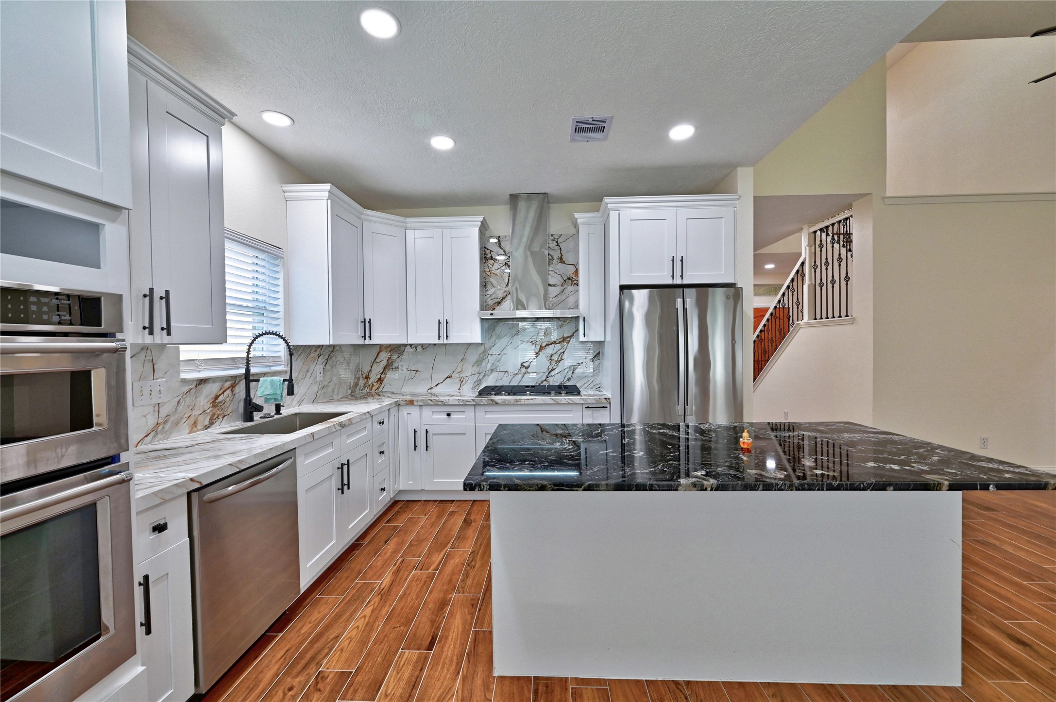 17907 Pelican Way Road Houston, TX 77084 - Photo 13 of 38 a kitchen with stainless steel appliances granite countertop a refrigerator a sink dishwasher a stove and white countertops with wooden floor