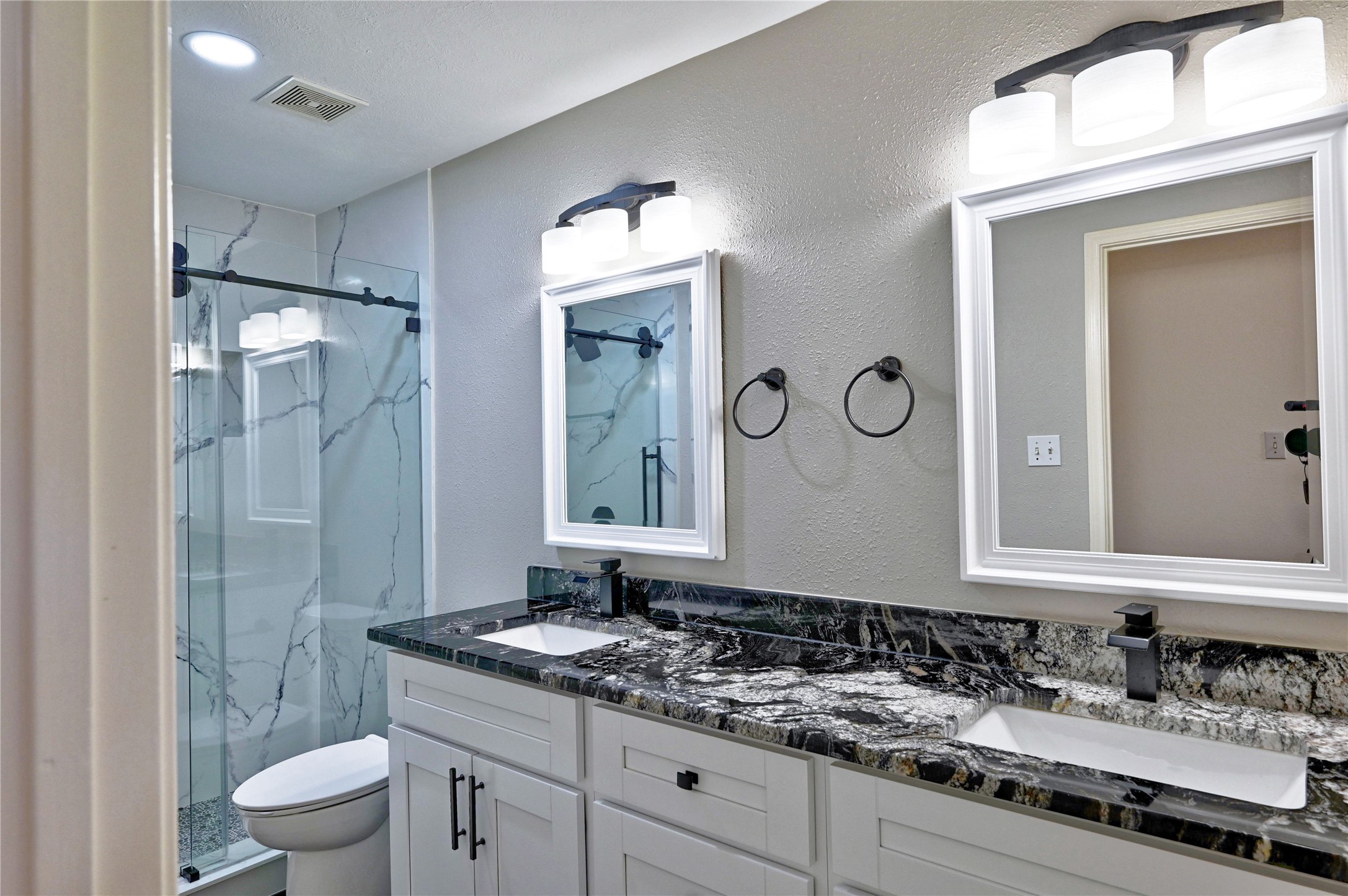 17907 Pelican Way Road Houston, TX 77084 - Photo 32 of 38 a bathroom with a granite countertop sink toilet a mirror and shower